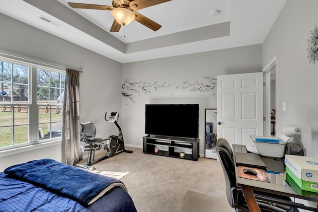 carpeted bedroom featuring visible vents, ceiling fan, a raised ceiling, and baseboards