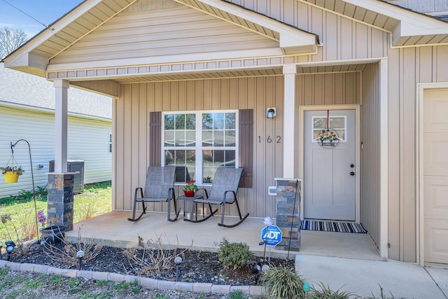 view of exterior entry with a porch and board and batten siding