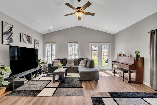 living room with light wood-type flooring, a ceiling fan, vaulted ceiling, and french doors