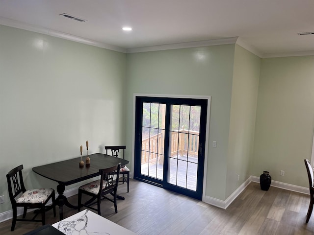 dining room featuring ornamental molding and light wood-type flooring