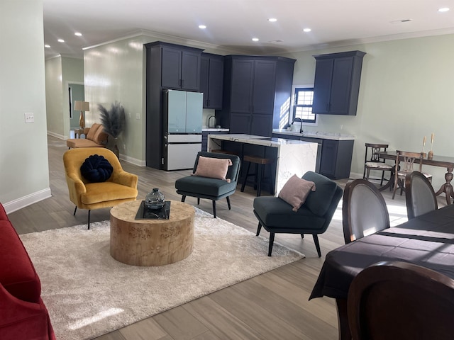 living room with light hardwood / wood-style floors and crown molding