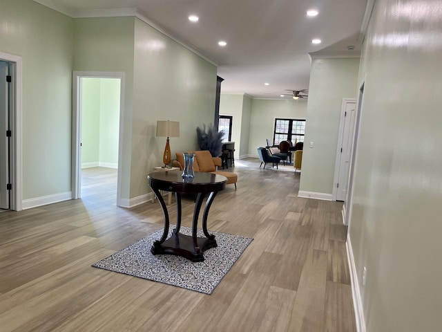 hallway featuring ornamental molding and light hardwood / wood-style flooring