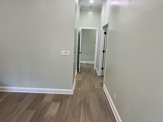 corridor with hardwood / wood-style floors and crown molding