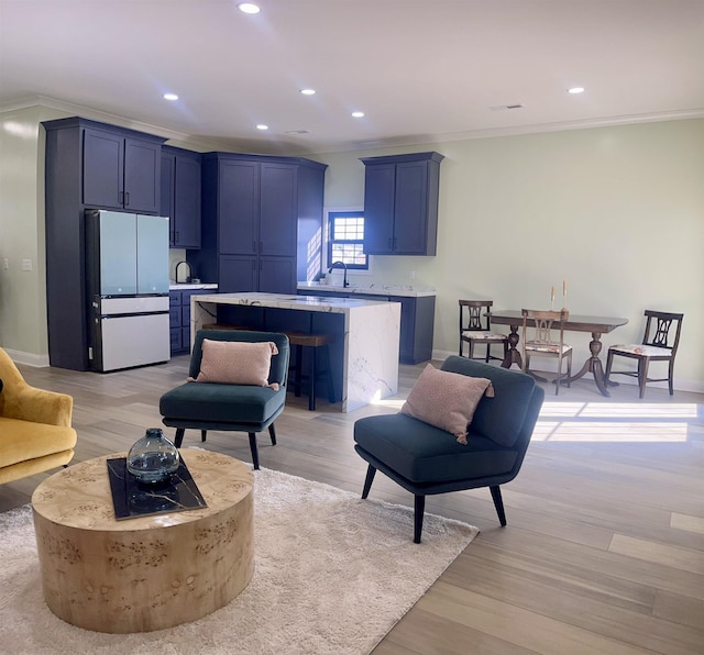 living room featuring crown molding and light hardwood / wood-style flooring