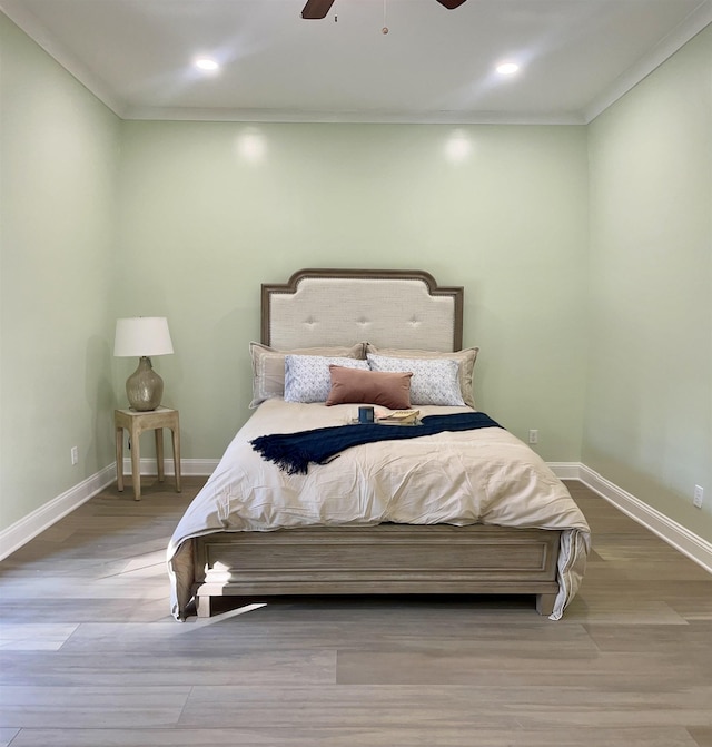 bedroom with ceiling fan, ornamental molding, and light hardwood / wood-style flooring