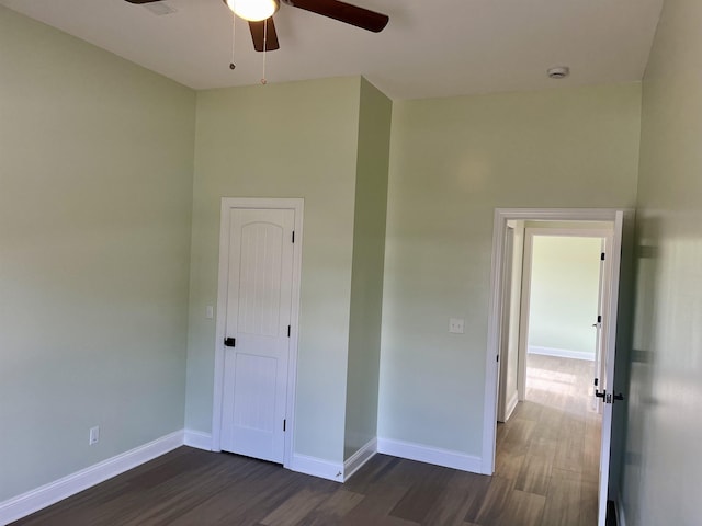 unfurnished bedroom with ceiling fan, a closet, and dark hardwood / wood-style floors