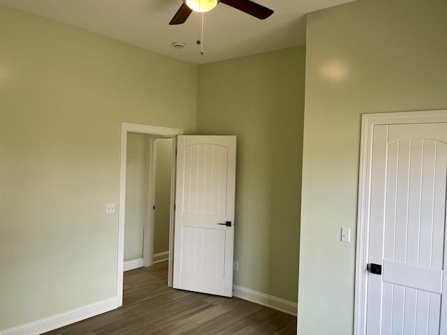 unfurnished bedroom featuring ceiling fan and dark hardwood / wood-style floors