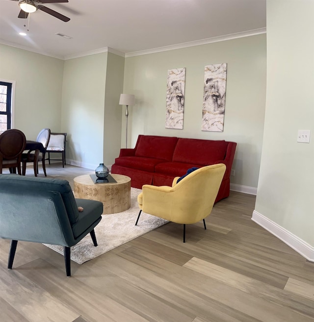 living room with light wood-type flooring, ceiling fan, and crown molding