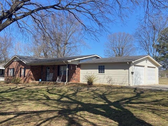 exterior space with a yard, brick siding, and an attached garage