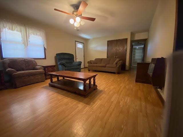 living area with a ceiling fan and light wood-style floors