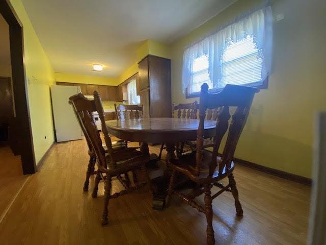 dining area with light wood finished floors and baseboards