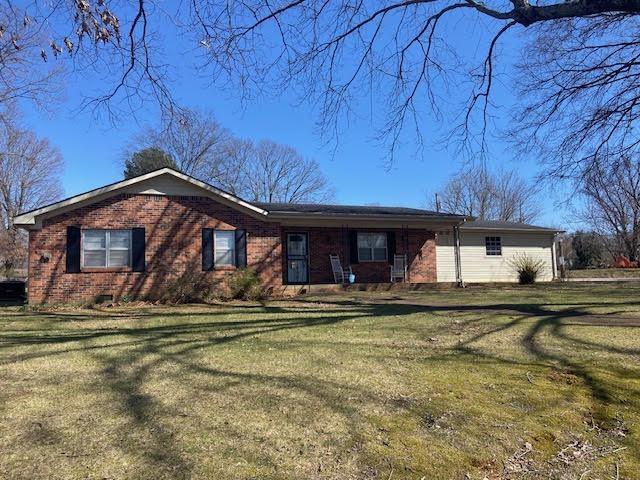 single story home with brick siding and a front lawn