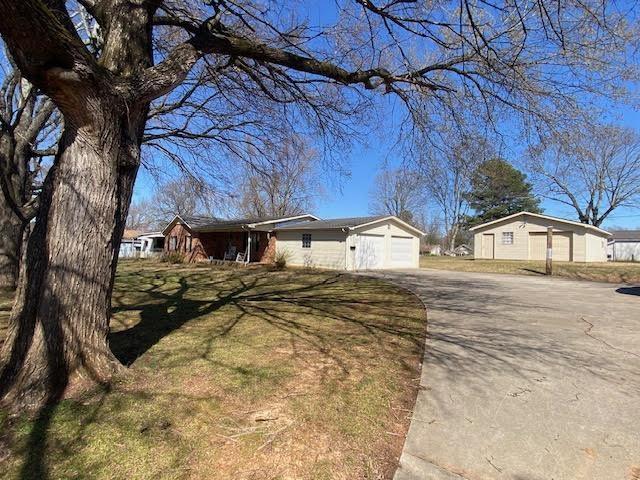 view of front of home with a garage, concrete driveway, and a front yard