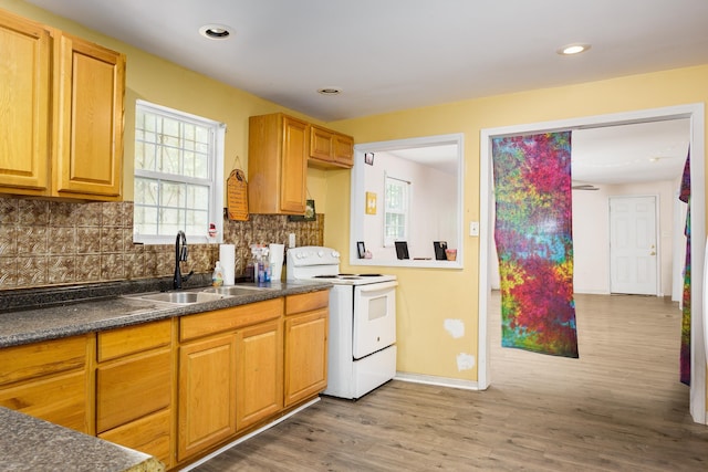  - kitchen with white electric stove, dark countertops, wood finished floors, tasteful backsplash, and recessed lighting