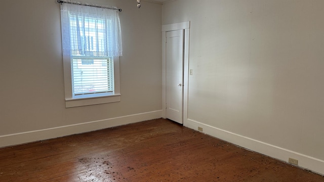 spare room with plenty of natural light and dark wood-type flooring