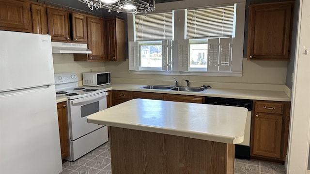 kitchen with white appliances, sink, a chandelier, a center island, and light tile patterned flooring