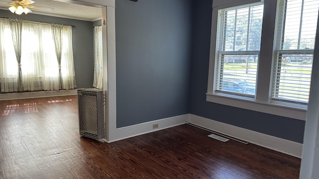 unfurnished room featuring a textured ceiling, ceiling fan, and dark wood-type flooring