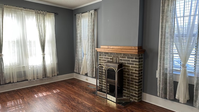 unfurnished living room featuring crown molding, hardwood / wood-style floors, a healthy amount of sunlight, and a textured ceiling