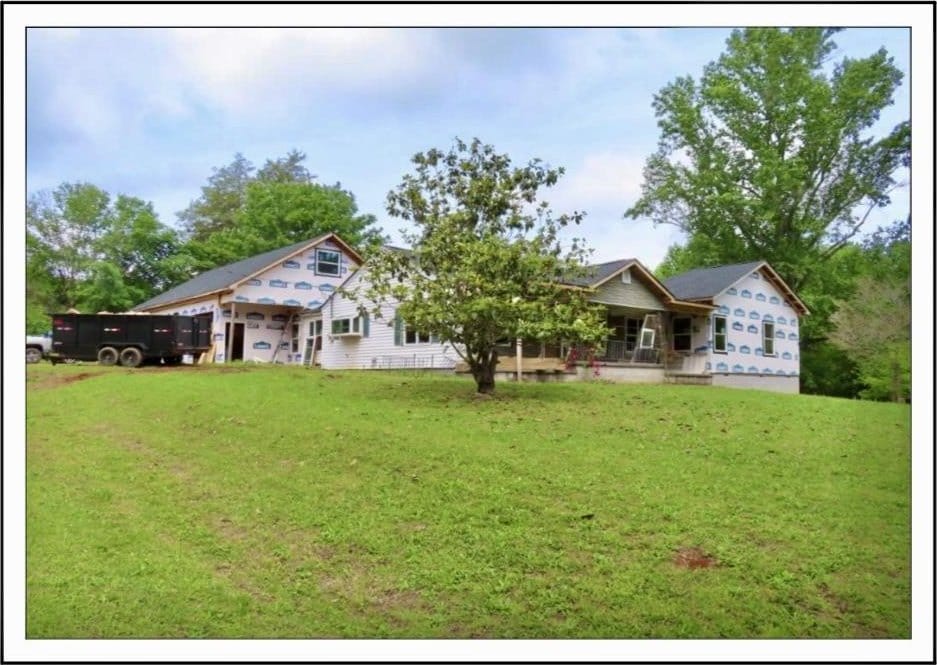  - rear view of property featuring a lawn and a porch