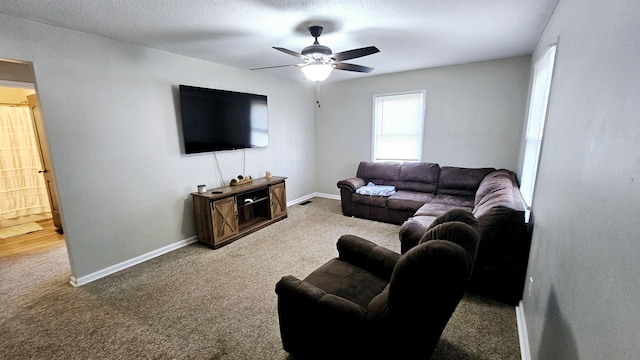 living room featuring ceiling fan, carpet floors, and a textured ceiling