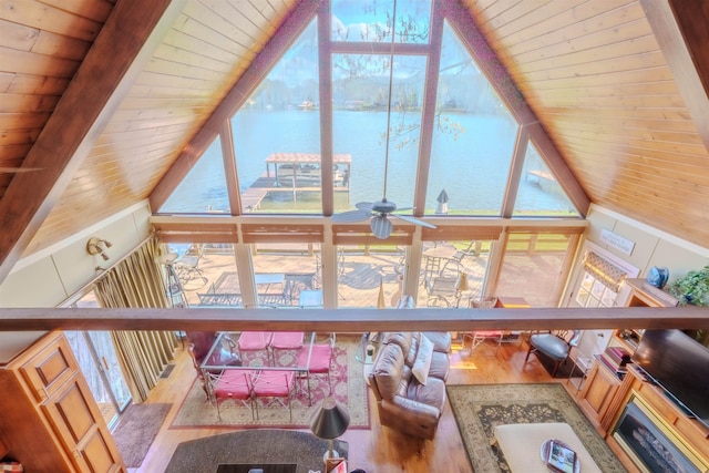living room with expansive windows, wood finished floors, a water view, and a healthy amount of sunlight