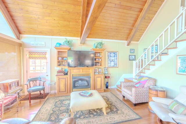 living room with vaulted ceiling with beams, wood finished floors, stairway, and wooden ceiling