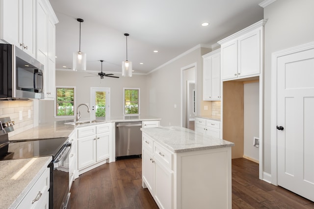 kitchen with ceiling fan, a center island, tasteful backsplash, kitchen peninsula, and appliances with stainless steel finishes