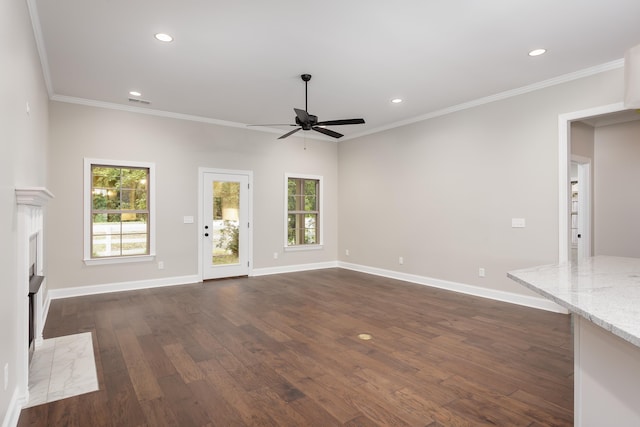 unfurnished living room with ceiling fan, ornamental molding, and dark wood-type flooring