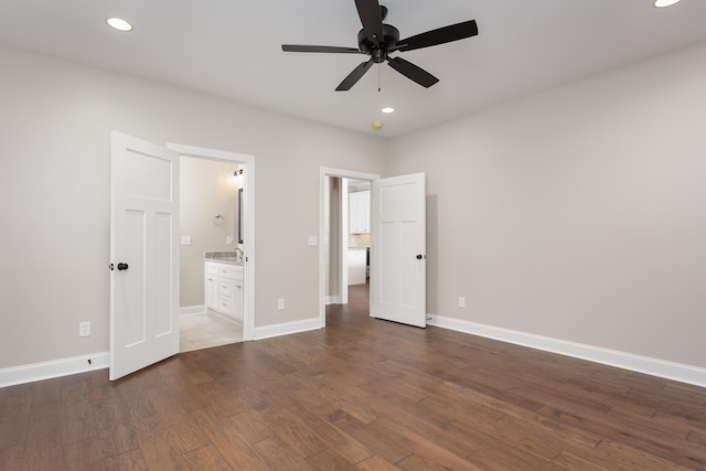 unfurnished bedroom with connected bathroom, dark hardwood / wood-style floors, and ceiling fan