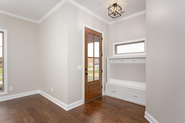 foyer entrance featuring ornamental molding, dark wood-type flooring, and a chandelier