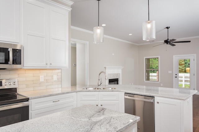 kitchen featuring white cabinetry, sink, hanging light fixtures, decorative backsplash, and appliances with stainless steel finishes