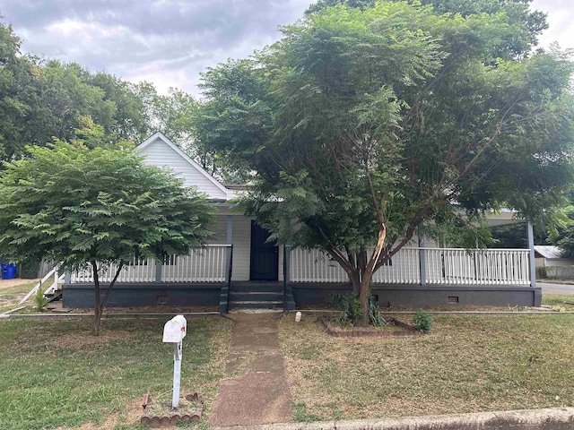 view of property hidden behind natural elements with a front yard