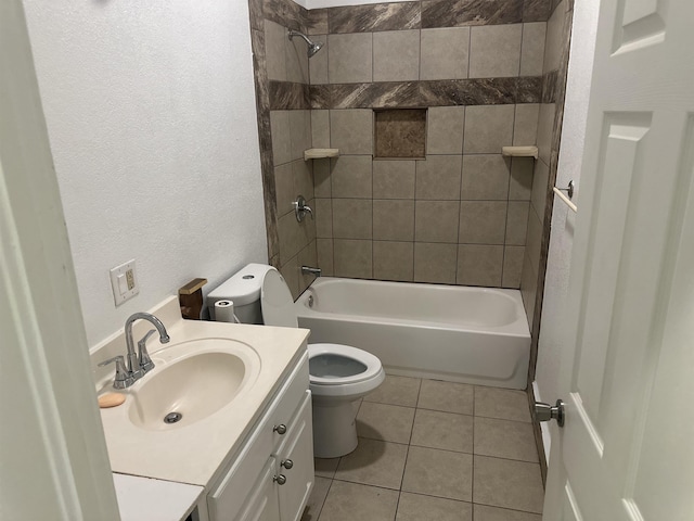 full bathroom featuring tile patterned flooring, vanity, toilet, and tiled shower / bath combo