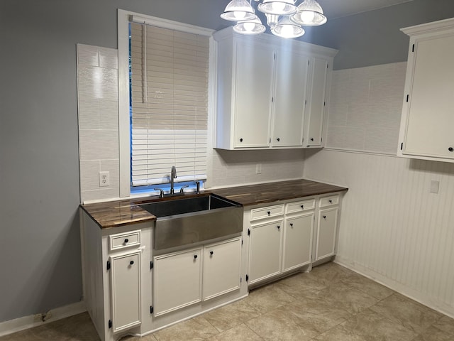 kitchen with white cabinets, a notable chandelier, and sink