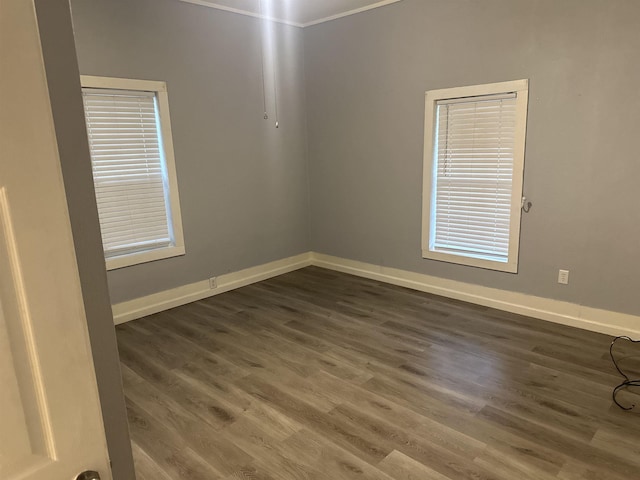 empty room with dark hardwood / wood-style flooring and ornamental molding