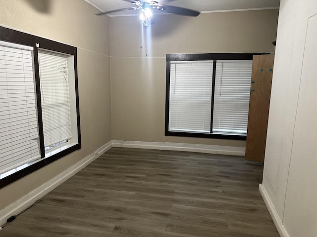 spare room featuring ceiling fan, ornamental molding, and dark wood-type flooring