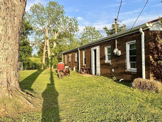  - view of home's exterior with a yard and brick siding
