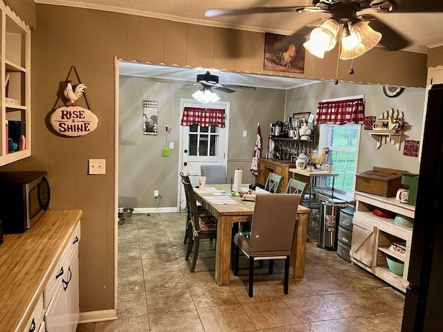  - tiled dining area with a ceiling fan and ornamental molding