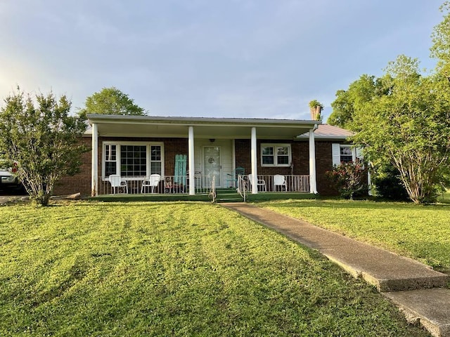 - ranch-style house featuring covered porch, brick siding, and a front lawn
