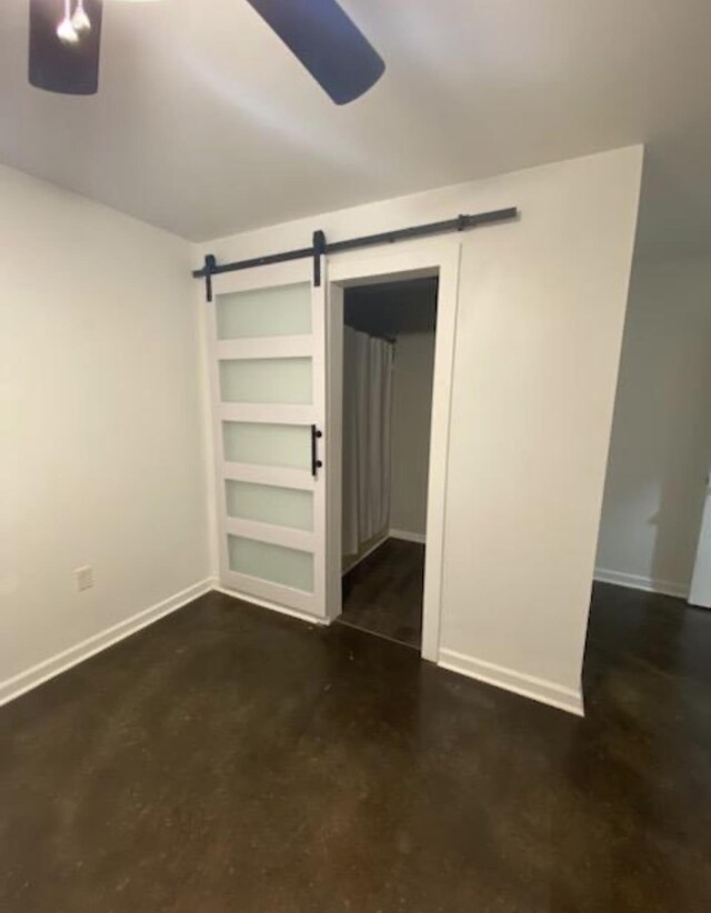  - unfurnished bedroom featuring a barn door, a closet, and concrete flooring