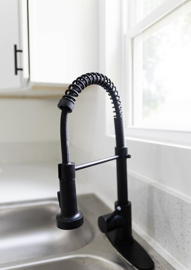  - kitchen view of a sink and white cabinets