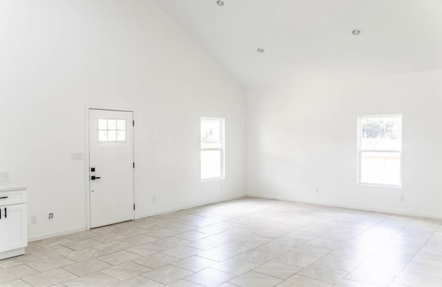  - unfurnished room featuring high vaulted ceiling and baseboards