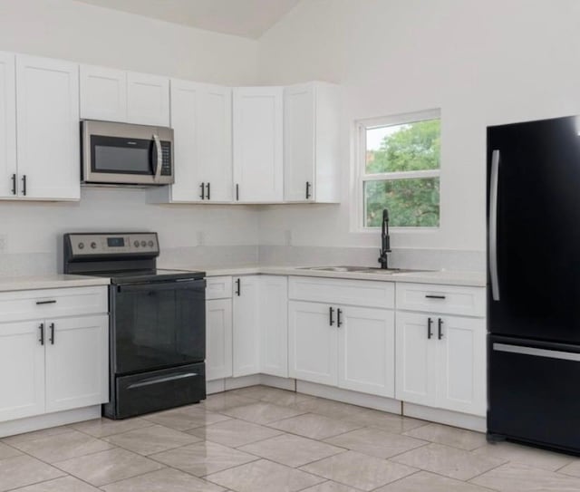  - kitchen featuring black appliances, light countertops, white cabinets, and lofted ceiling