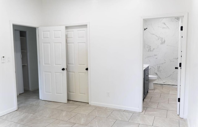  - unfurnished bedroom featuring a closet and ensuite bathroom