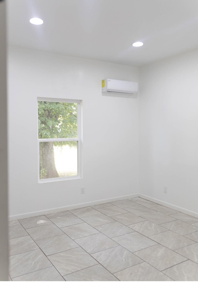  - spare room featuring a wall mounted air conditioner and recessed lighting