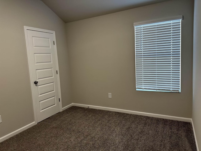 carpeted spare room with lofted ceiling