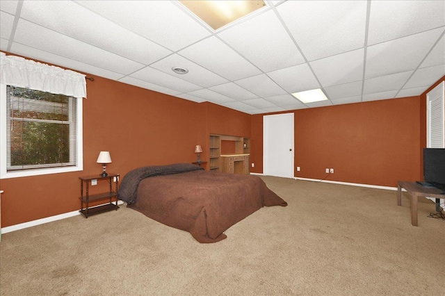 bedroom with a drop ceiling and carpet