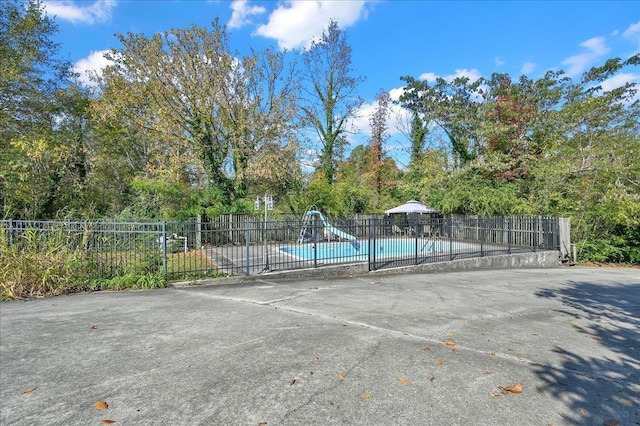 view of sport court featuring a patio and a fenced in pool