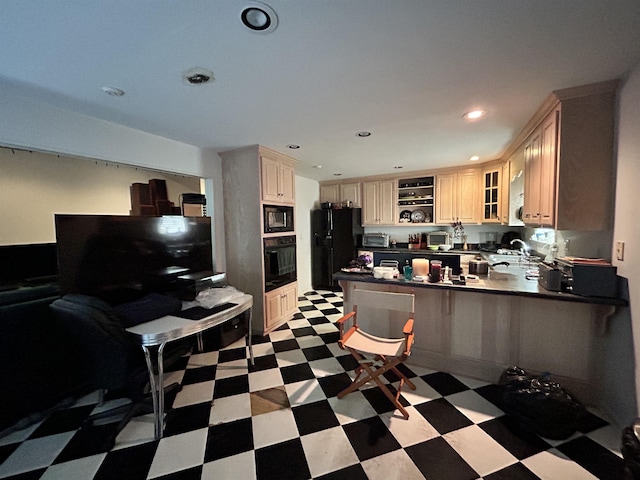 kitchen with a breakfast bar area, kitchen peninsula, sink, and black appliances