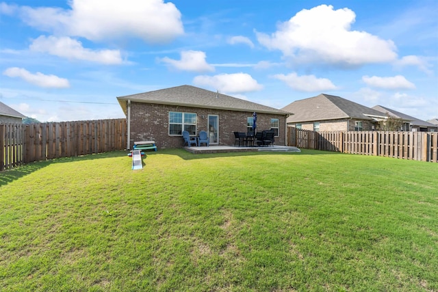 back of house with a patio area and a yard